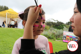 Lelle Ota stands still while her face is painted.