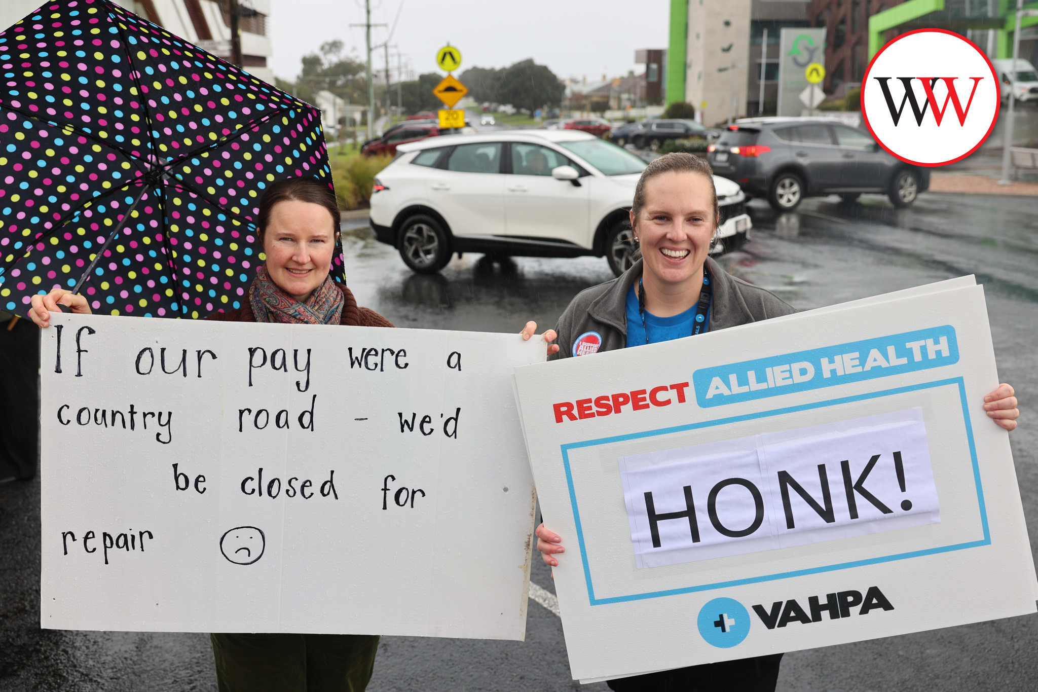 Social worker Louise Rothman (left) and occupational therapist Rachael Couch were happy to stand in the rain to help spread their message.