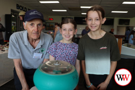 Warrnambool sisters Elsie and Zara Packer enjoy a close look at how gems are washed with club member, Alan Altmanu.