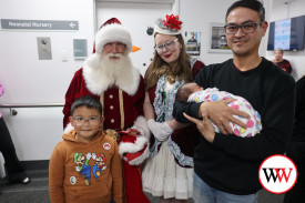 Romie Bondoc (right) with son Austin and newborn Adam enjoyed meeting Santa and listening to carols.