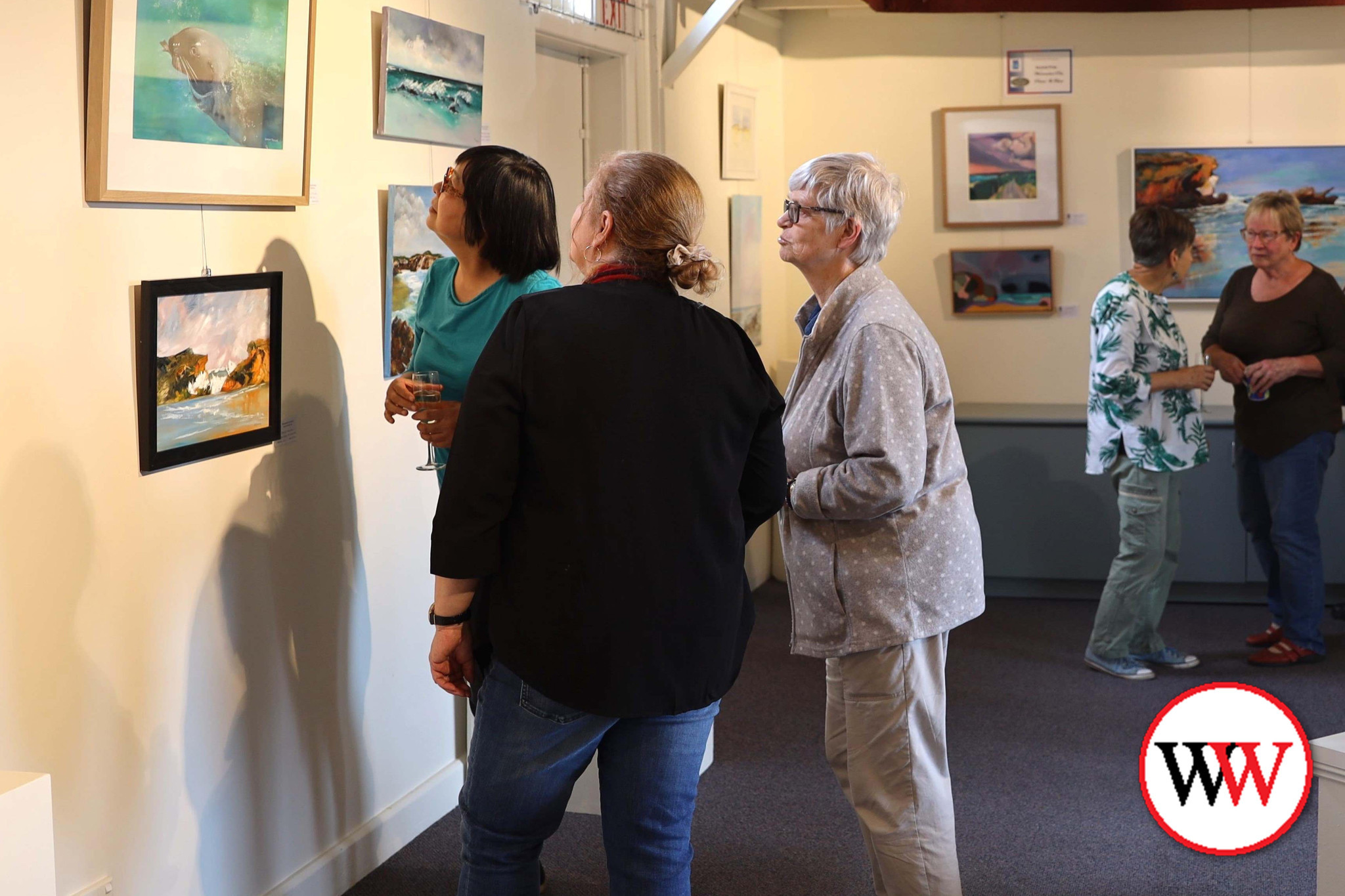 Visitors enjoy the pieces on display in the art gallery.
