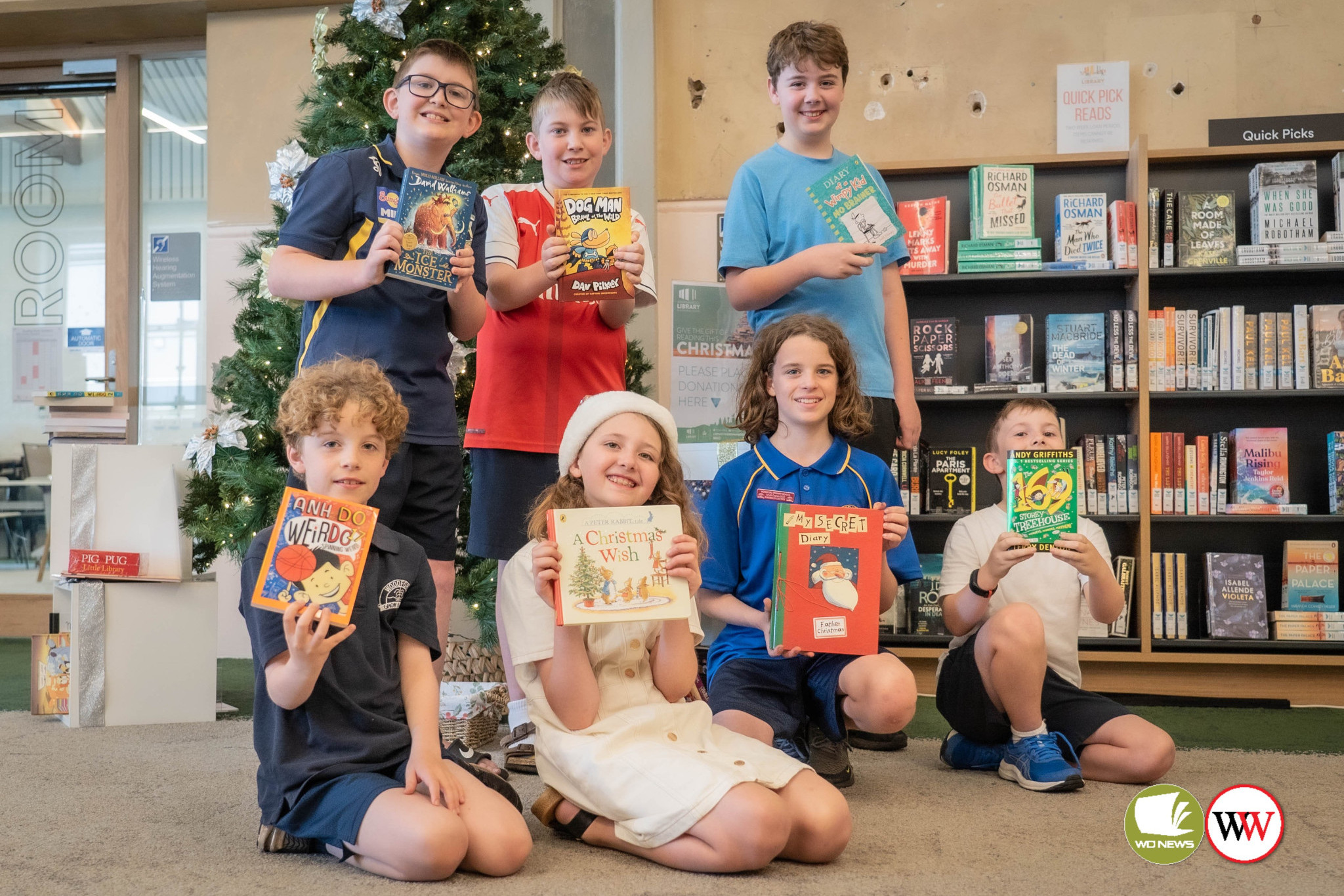 The gift of giving: Henry Ezzy, Albie Ezzy and Rohan Elliott, together with (front row) Charlie Grundy, Lucy Elliott, Harrison Grundy and George Ezzy were happy to donate a book.