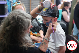 Four year-old Archer Clarke sits patiently while his face is painted.