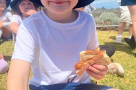 Levi Rylance enjoys a free sausage at the family barbecue.